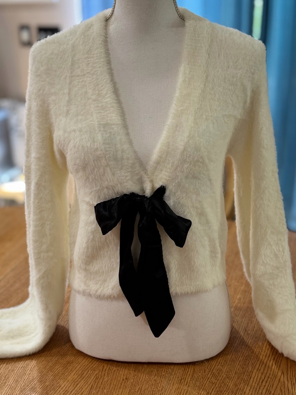 Dolls Kill Ivory Fuzzy V-Neck Cardigan with Black Bow